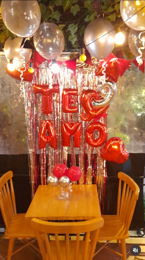 Mesa para celebrar con globos rojos y dorados